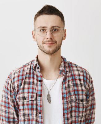Waist-up portrait of calm and successful young businessman, wearing glasses and smiling at camera. Young entrepreneur listens to customers complaints. Office worker on meeting with boss. Emotions concept