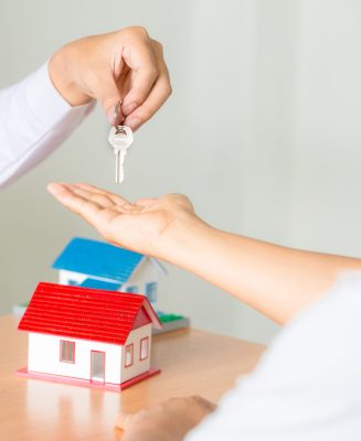 Real estate Sales manager giving keys to customer after signing rental lease contract of sale purchase agreement, concerning mortgage loan offer for and house insurance.